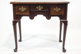 A George III mahogany low boy with three drawers, shaped apron turned tapering legs and pad feet,