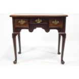 A George III mahogany low boy with three drawers, shaped apron turned tapering legs and pad feet,