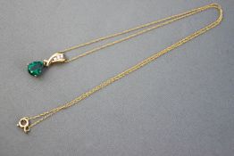 A yellow metal created (synthetic) emerald and diamond pendant