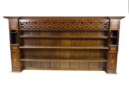 An oak dresser rack, in George III style, with unusual pierced frieze above three open shelves,