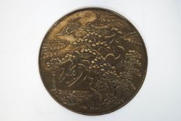 A Japanese bronze mirror, cast with cranes and trees,