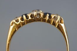 A yellow metal half hoop ring set with a central old European cut diamond