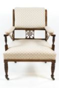 An Edwardian rosewood armchair the upholstered back with pierced panel,