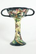 A Moorcroft 'Astrantia' pattern two handled chalice, on a blue and ivory ground,