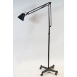 A floor standing angle poise lamp in black painted metal,