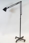 A floor standing angle poise lamp in black painted metal,