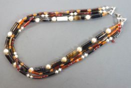 A three strand necklace strung with cylindrical banded agate,