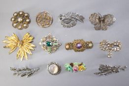 A collection of twenty two costume brooches of variable designs.