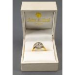 A yellow and white metal cluster ring. Set with nine variable sized old cut diamonds.