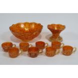 A Carnival glass punch bowl on stand, with six matching cups,