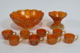 A Carnival glass punch bowl on stand, with six matching cups,