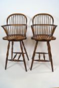 A pair of Fauld elm Windsor style high chairs each with swivel seats,