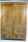 A 19th century mahogany wardrobe with two panelled doors above two drawers on bracket feet,