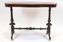 A Victorian rosewood salon table, of oval serpentine outline, supported on two baluster legs,