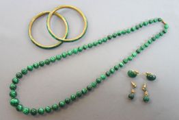 A collection of jewellery to include: Two gold plated malachite bangles;