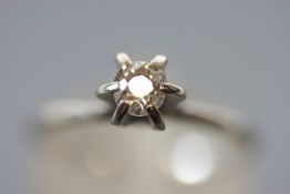 A white metal single stone ring. Set with an old European cut diamond of approximately 0.25cts.