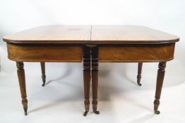 A 19th century mahogany dining table with reeded edge to the shaped ends and two loose leaves