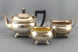 A silver bachelor tea set of bellied form with domed cover raised on plain ball feet,