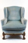 A large wing back armchair, upholstered in pale blue velvet,