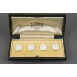 A collection of four white enamelled waistcoat buttons.