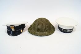 A WW2 British forces steel helmet with a Royal Navy officer's cap and a Royal Navy 'H M Submarines'