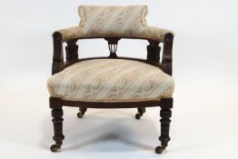 An Edwardian tub shaped chair, the back rail supported on three carved foliate splats,