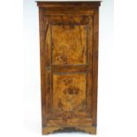 An elm panelled cupboard, the hinged door with two recessed panels, enclosing three shelves,