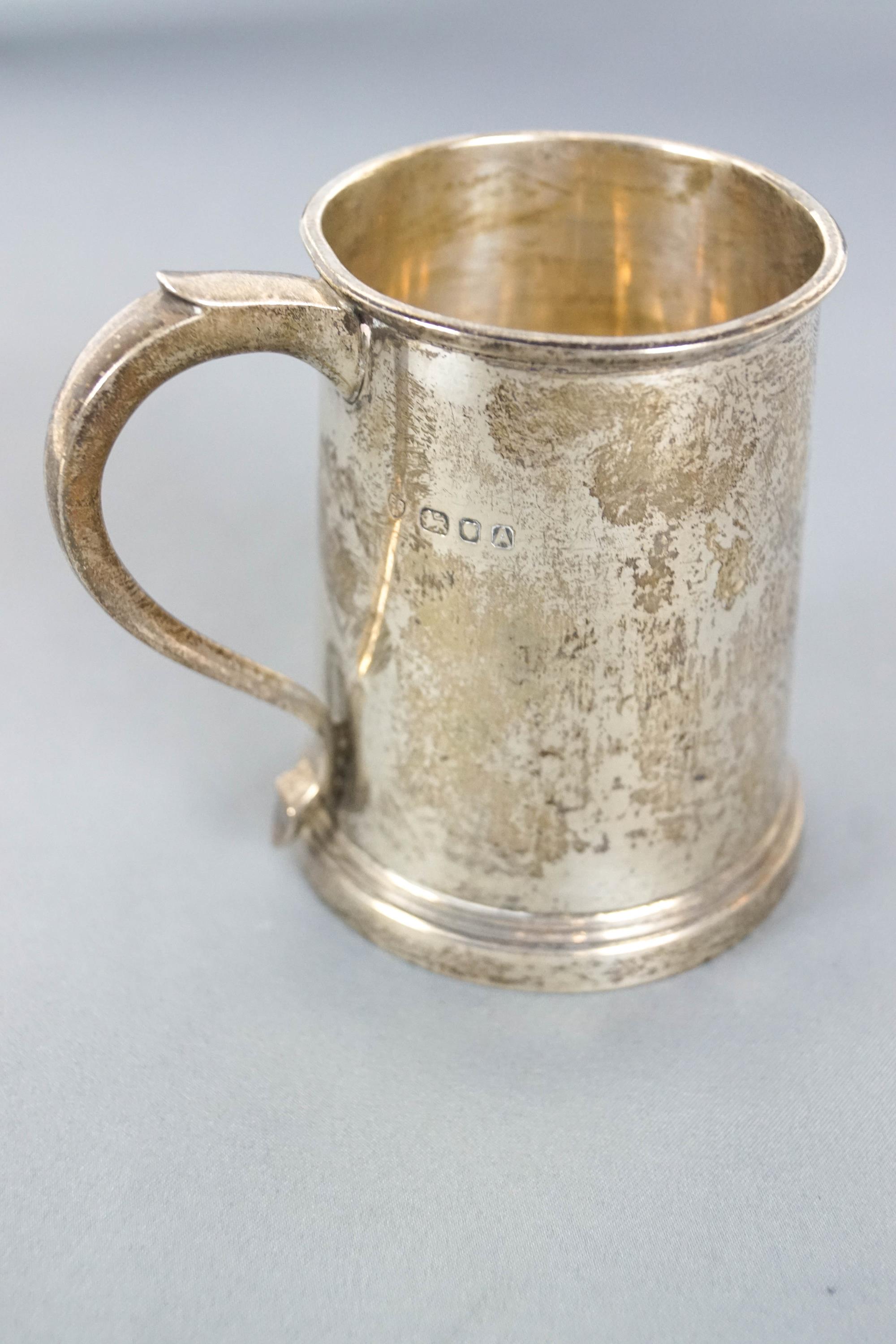 A small silver mug, of plain tapering cylindrical form, with a scroll handle, London 1936, 9cm high, - Image 2 of 2