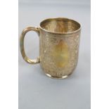 A small silver mug, of rounded form, decorated with engraved quatrefoils and strapwork,