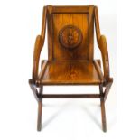 An oak Glastonbury chair, in traditional form, the back carved with a roundel,