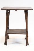 An oak Arts and Crafts style two tier occasional table, on four shaped and pierced supports,