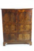 A 19th century mahogany standing cupboard with six panelled doors on bracket feet,