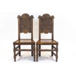 A pair of oak carved hall chairs, in the 16th century style,