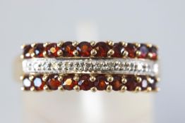 A yellow metal three row half hoop ring set with two rows of garnets