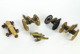 Five brass and wooden mounted miniature models of cannons,