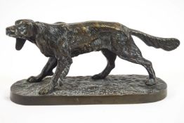 A bronze model of a retriever, naturalistically modelled on a rocky oval base,