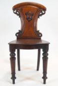 A Victorian mahogany hall chair with foliate carved back, with shield on turned legs,