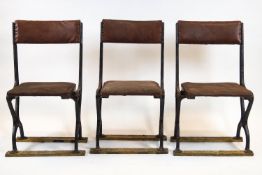 A set of three folding chairs, probably railway, with cast iron frames and studded brown upholstery,