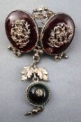 A white metal antique brooch stylized as two oval garnets each embellished with open work leaf