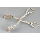 A pair of Continental cast white metal cake tongs, decorated with foliate motifs, 15cm long,