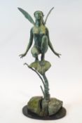 A 20th century bronze statue of a fairy, crouched on a leaf supported by branches and rocks,