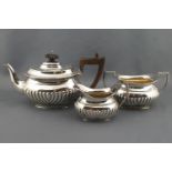 A silver bachelor three piece tea service of bellied half reeded form,