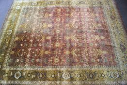 A large Persian style machine woven wool rug with overall stylised repeating flowers on a red