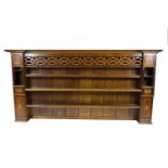 An oak dresser rack, in George III style, with unusual pierced frieze above three open shelves,