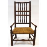 An 18th century style spindle back low armchair with rope seat and turned legs,