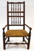 An 18th century style spindle back low armchair with rope seat and turned legs,