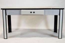 A 1950's white enamel table with black enamel banding and one frieze drawer on square legs,