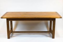 A rectangular farmhouse table, the oak top on base with chamfered rectangular feet,