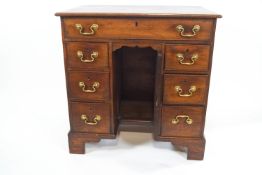 A George III mahogany kneehole desk with one frieze drawers above three drawers