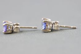 A white metal single stone pair of stud earrings.